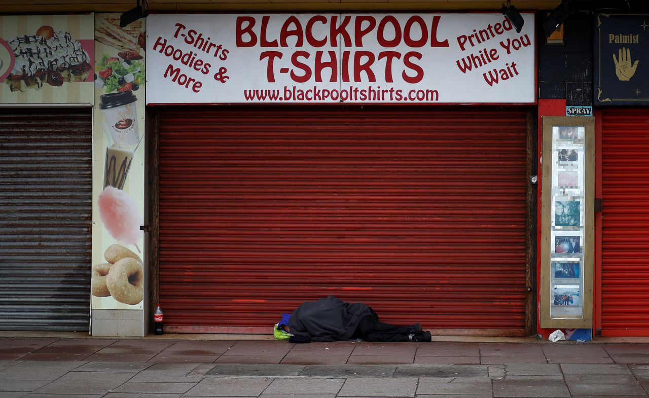 A man sleeps in the doorway of a souvenir shop in Blackpool.