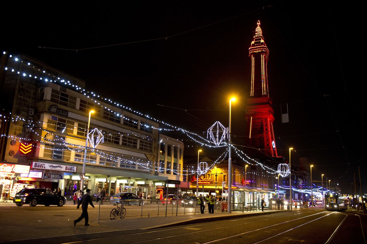 Members of the public admire the Blackpool Illuminations as they walk along the promenade in Blackpool, northern England.