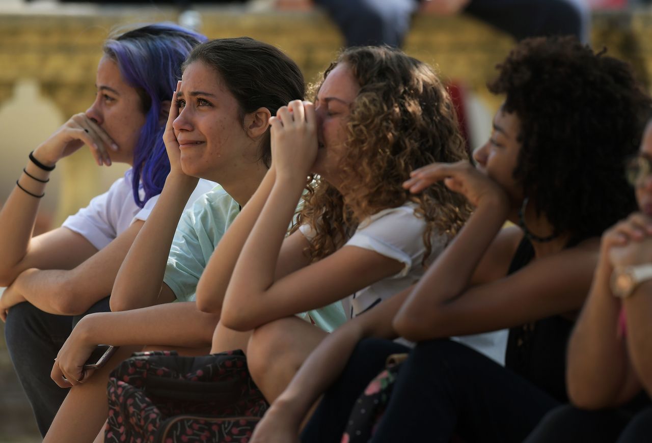 People cry a day after a massive fire ripped through Rio de Janeiro's treasured National Museum