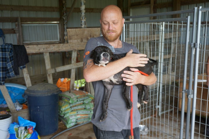 An ASPCA rescuer carries one of the dogs found on the property.