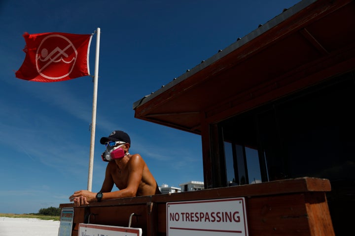 Sarasota County Emergency Services lifeguard Mariano Martinez wears a mask because of red tide at Lido Beach on Aug. 26.