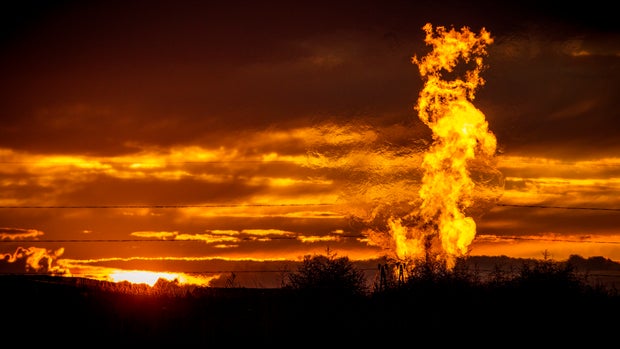 Flames from a flaring pit near a well in the Bakken Oil Field. The primary component of natural gas is methane, which is odorless when it comes directly out of the gas well. In addition to methane, natural gas typically contains other hydrocarbons such as ethane, propane, butane, and pentanes. Raw natural gas may also contain water vapor, hydrogen sulfide (H2S), carbon dioxide, helium, nitrogen, and other compounds. (Source: www.earthworksaction.org). As of July 2014, roughly 30 percent of the (Photo by Orjan F. Ellingvag/Corbis via Getty Images)