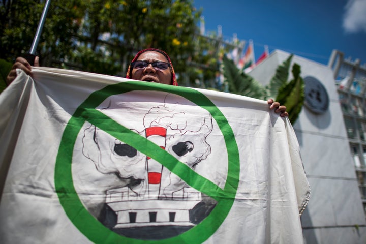 An environmental activist shouts slogans during a demonstration in front of the United Nations building in Bangkok on Sept. 7, 2018