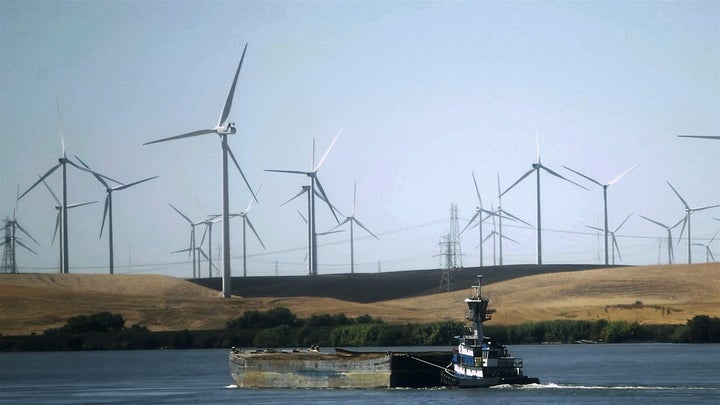 Windmills are scattered along the Sacramento River near Rio Vista, California. The state recently became the second, following Hawaii, to require that 100 percent of its electricity come from renewables by 2045. 