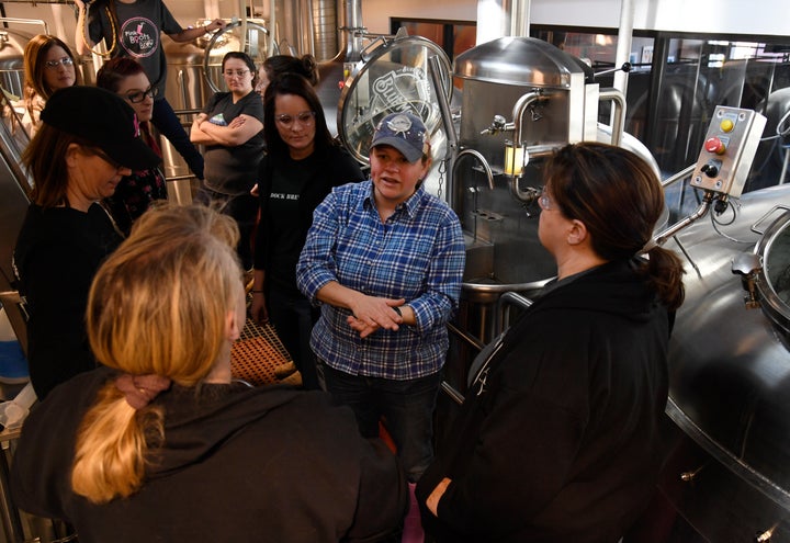 Blue Moon Brewing Co. brewer, Emilie Stewart, center, talks with women brewers during a Pink Boots Society event at Blue Moon in March 2018.