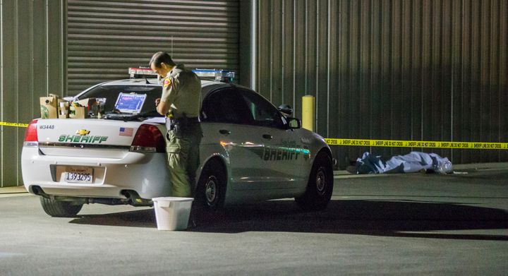 A Kern County sheriff's deputy collects evidence after a series of shootings on Wednesday in Bakersfield, Calif.