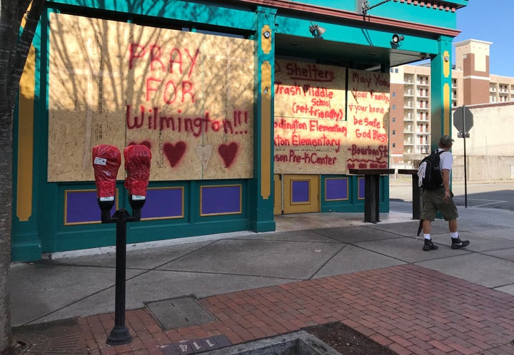 A man walks past boarded-up storefronts ahead of the arrival of Hurricane Florence in downtown Wilmington, North Carolina, U.S., Sept. 12, 2018