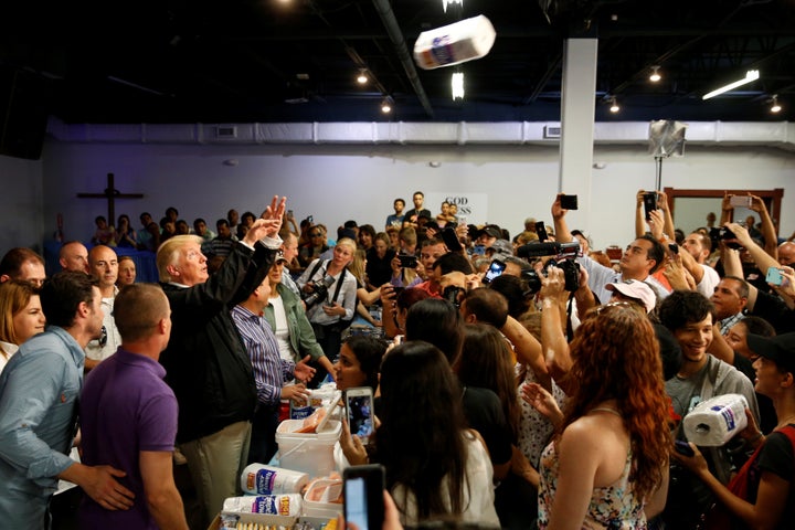 President Donald Trump tosses rolls of paper towels to people at a hurricane relief distribution center in San Juan on Oct. 3