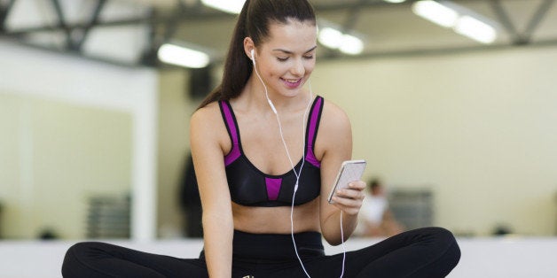 fitness, sport, training, gym, technology and lifestyle concept - smiling woman with smartphone