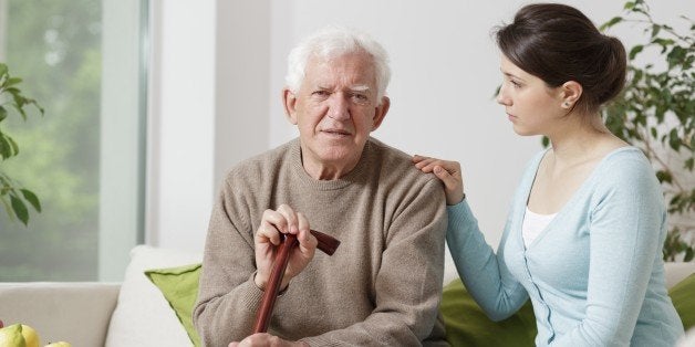 Image of elderly man with walking stick and his carer