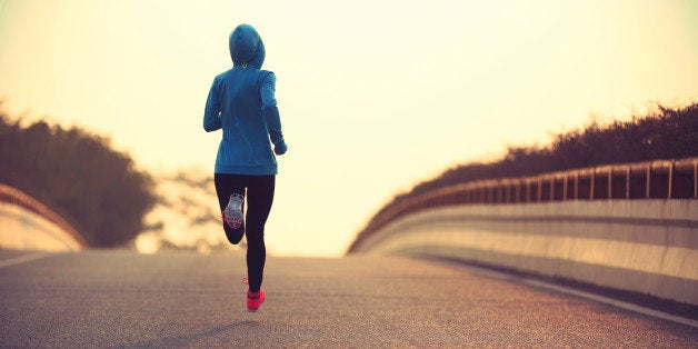 young fitness woman trail runner running on city road