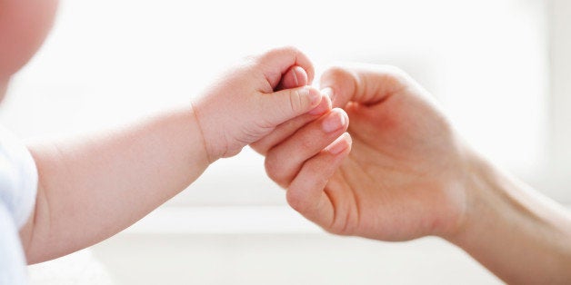 Baby holding mother's finger