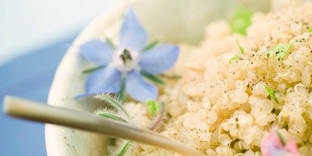 Bowl of quinoa, garnished with flowers, cropped view