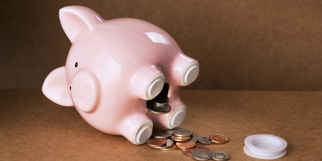 Piggy bank spilling out change onto counter