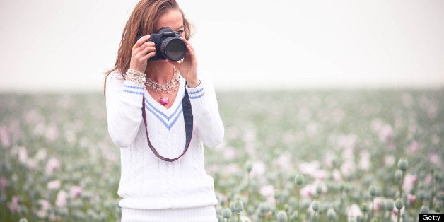 Young photographer in opium poppy field.