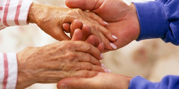 Man holding elderly woman's hands