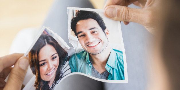 Woman tearing picture of herself with ex-boyfriend