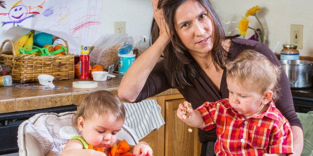 Stressed out mother in kitchen with her babies