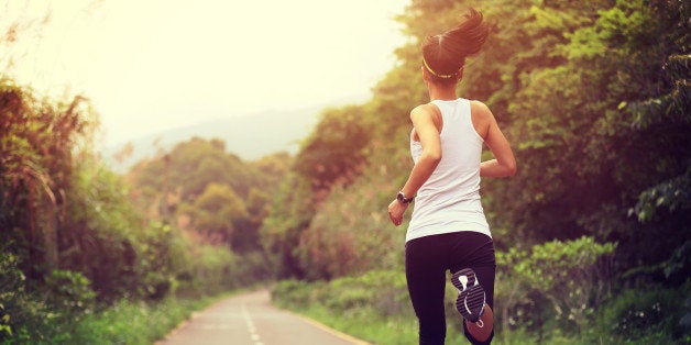 young fitness woman runner running at forest trail