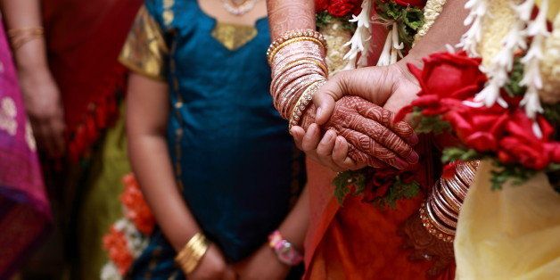 Indian wedding ceremony with the bride's hand in the groom's.