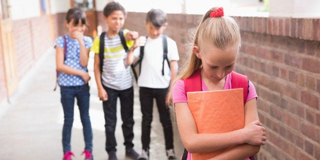 Pupils friends teasing a pupil alone in elementary school 