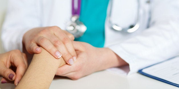 Female doctor's hands holding patient's hand for encouragement and empathy. Partnership, trust and medical ethics concept. Bad news lessening and support.