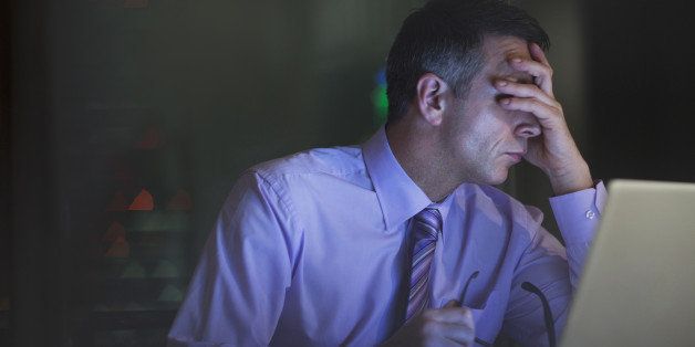 Tired businessman working late at laptop