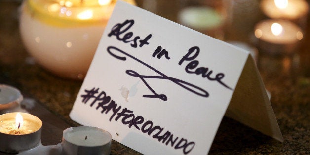A note is placed at an impromptu candle-lit memorial set up in Sydney, Monday, June 13, 2016, following the Florida mass shooting at the Pulse Orlando nightclub where police say a gunman wielding an assault-type rifle opened fire, killing at least 50 people and wounding dozens. Australian Prime Minister Malcolm Turnbull said that the Orlando mass shooting was "an attack on all of us ᅢ까タᅡヤ on all our freedoms, the freedom to gather together, to celebrate, to share time with friends." (AP Photo/Rick Rycroft)