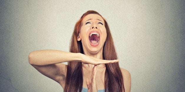 Young woman showing time out hand gesture, frustrated screaming to stop isolated on grey wall background. Too many things to do. Human emotions face expression reaction