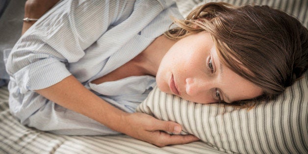 Young woman lying on her bed