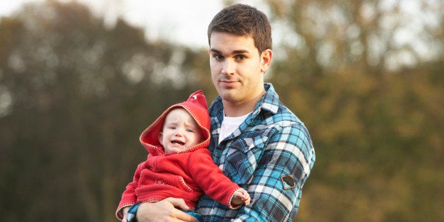 Shocked Teenage Boy Holding Baby