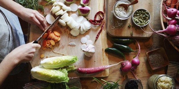 Woman cooking in kitchen with ingredients around her