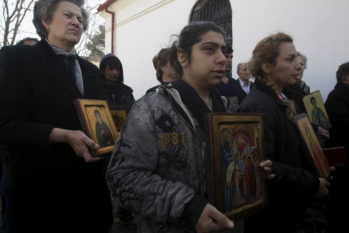 Christian Orthodox Iranian migrants hold icons during a Mass at a church in Idomeni, Greece, March 20, 2016. 