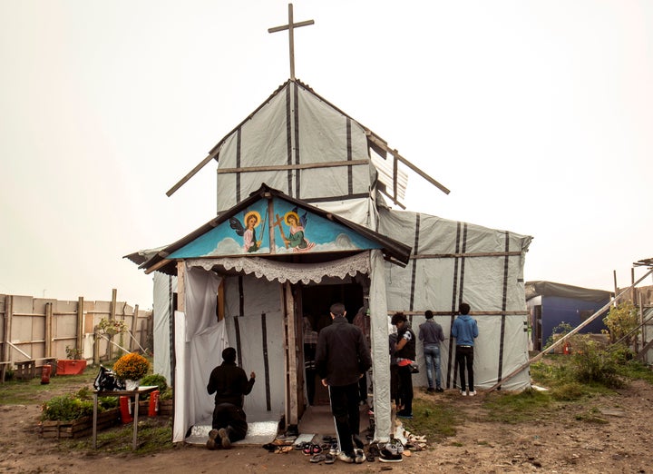 Ethiopian Coptic migrants arrive for a Mass at the makeshift Orthodox church in a migrant camp in Calais, northern France, on October 30, 2016.