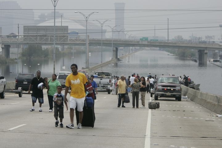 Residents of New Orleans rescued by police boats walk from floodwaters in front of the Superdome on Sept. 1, 2005.