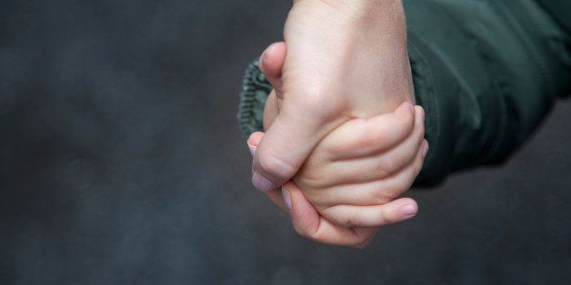 Child holding mother's hand. 