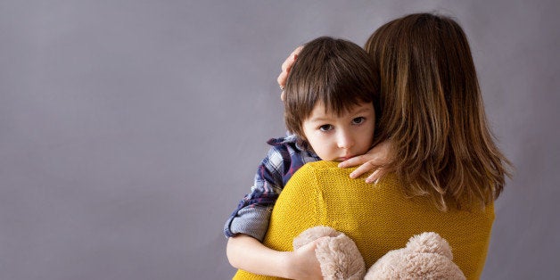 Sad little child, boy, hugging his mother at home, isolated image, copy space. Family concept