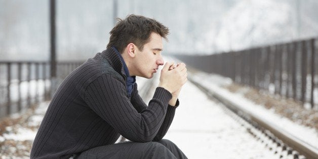 sad man in railroad track