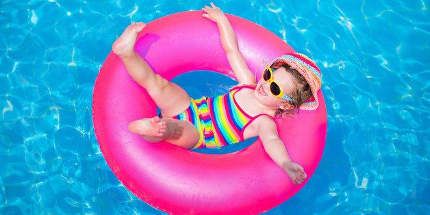 Child in swimming pool. Little girl playing in water. Vacation and traveling with kids. Children play outdoors in summer. Kid with inflatable ring toy. Swim wear and sun glasses for UV protection.
