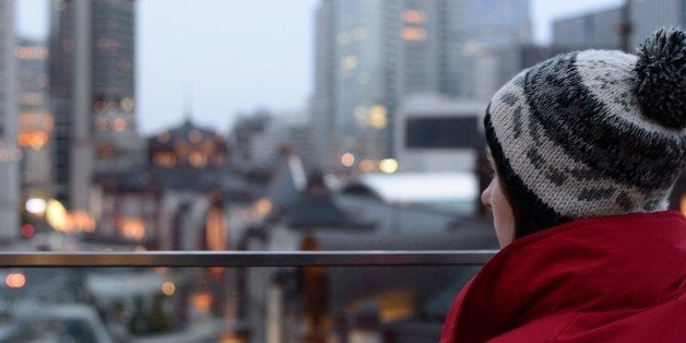 A young woman looking at Tokyo Station at dusk.