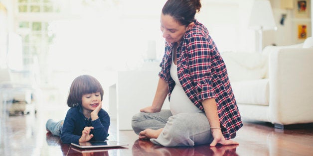 Small boy with his mother using a digital tablet