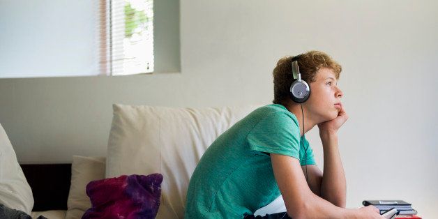 Teenage boy listening to music on a mobile phone