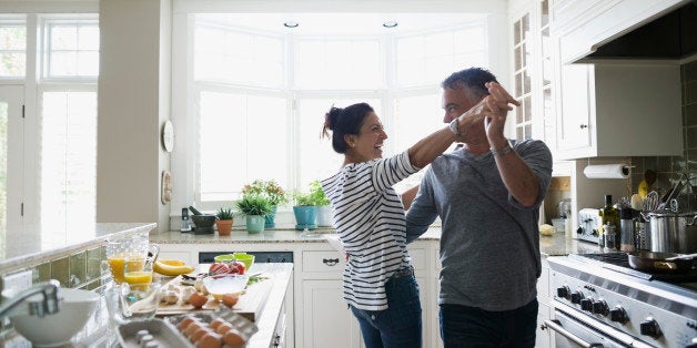 Playful couple dancing in kitchen