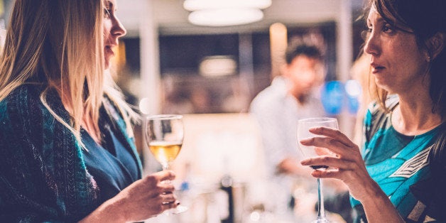 Two women talking to each other in a wine bar