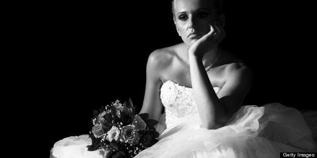 Sad bride sitting in the dark. Black and white.