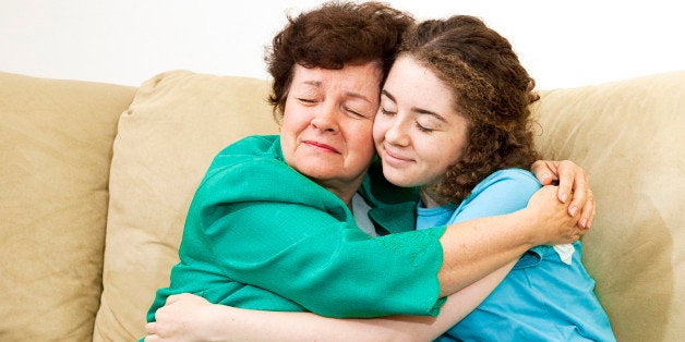 Mother and teenage daughter giving each other a big hug.