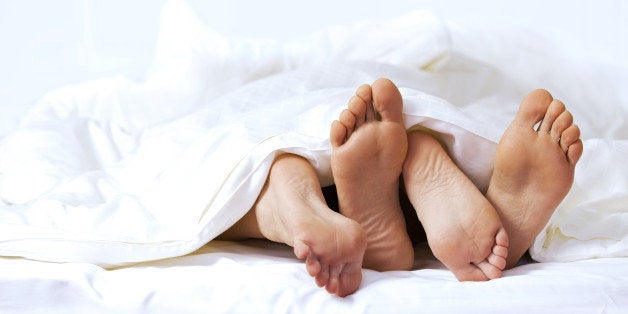 Close-up of the feet of a couple on the bed