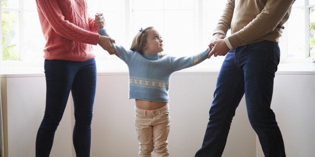 Two Parents Fighting Over Small Confused Child In Divorce Concept