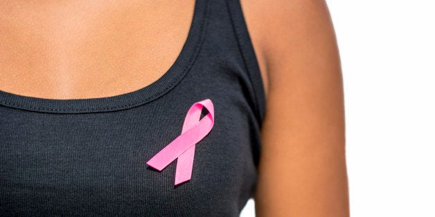 close up of african woman in t-shirt with breast cancer awareness ribbon over white background