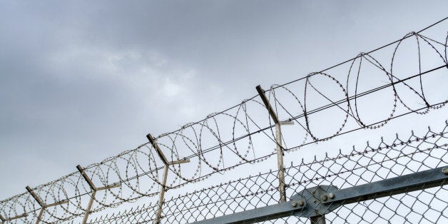 wired fence with barbed wires on blue sky background 